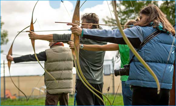 YMCA Archery club photo with archers drawing bows ready to shoot